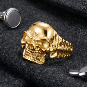 Macro close-up of a vintage golden titanium steel skull ring with detailed bone texture