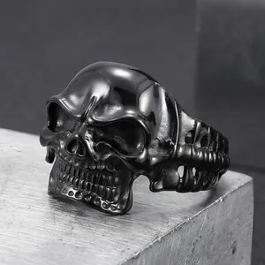 Close-up detail of a dark gothic skull ring featuring intricate bone-like band design.