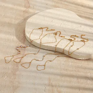 Détail des bracelets de doigt en acier inoxydable plaqué or 18K sur un support de pierre