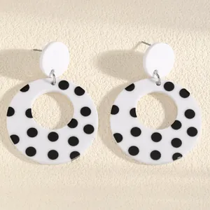 Close-up detail of retro style black and white polka dot acrylic hollow circle earrings