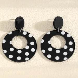 Detail of black and white polka dot acrylic hollow circle earrings with retro design