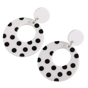 Detail of stylish black and white polka dot hollow circle acrylic drop earrings.