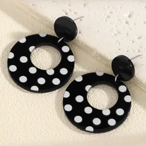 Detail view of retro black and white polka dot acrylic large hollow hoop earrings