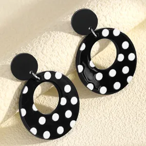 Detailed view of large black and white polka dot acrylic hollow hoop earrings