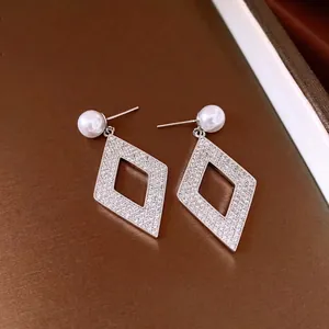 Elegantes pendientes de rombo hueco de plata con perlas blancas e incrustaciones de circón