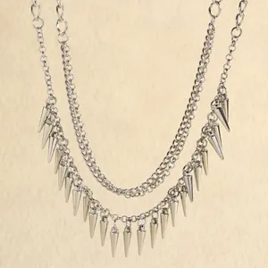 Close-up van zilveren punk dubbellaagse ketting met zware metalen kegelvormige spike kwast.