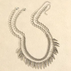 Detail van zilveren punk halsketting met dubbele laag en kegelvormige spikes