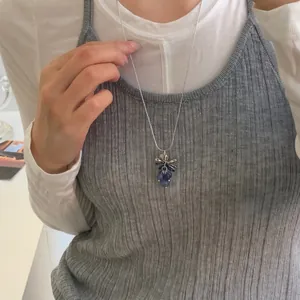 Vue détaillée d'un collier pendentif grappe de raisin élégant porté par un mannequin