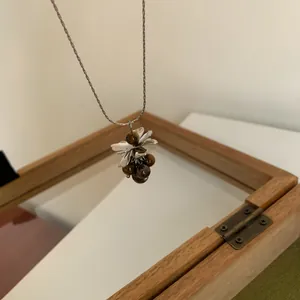 Vue détaillée du collier pendentif grappe de raisin avec perles en oeil de tigre.