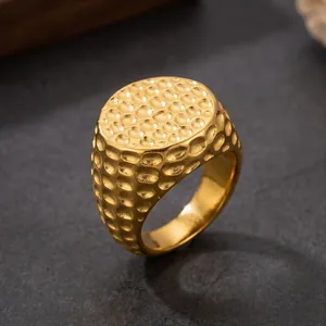 Detailopname van een gouden herenring van roestvrij staal met een hamerstructuur