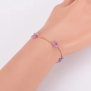Vue détaillée du bracelet de fleurs en perles violettes fait main avec chaîne dorée