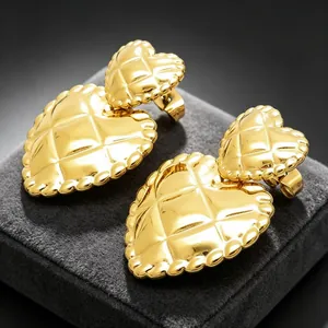 Detailed macro view of vintage gold quilted double heart titanium steel stud earrings