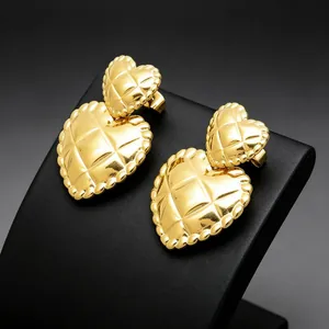 Detailed macro view of elegant gold quilted double heart earrings made from titanium steel