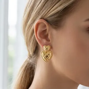 Close-up of elegant vintage gold-plated quilted double heart earrings on a model ear