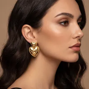 Detailed close-up view of vintage gold quilted double heart earrings worn by a model