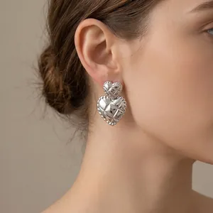 Silver quilted double heart earrings on model showing retro French style
