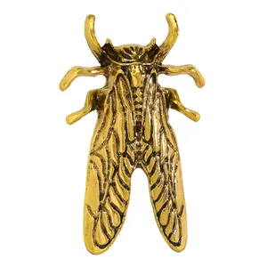 Dettaglio macro di una spilla a forma di cicala scarabeo dorata stile vintage uomo