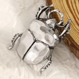 Dettaglio macro di una spilla a forma di scarabeo argentato in stile vintage