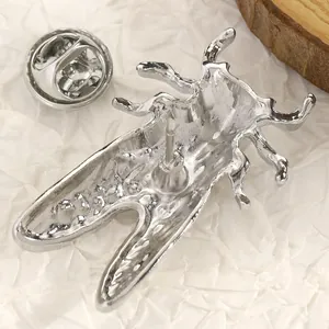 Dettagliata vista macro del retro di una spilla a forma di cicala argento con fermaglio