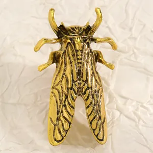 Vista dettagliata di una spilla a forma di cicala in oro vintage con ali incise