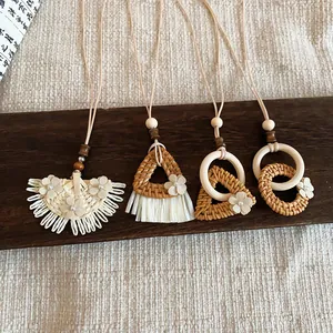 Selection of four handcrafted woven rattan pendants displayed on a rustic wooden board.