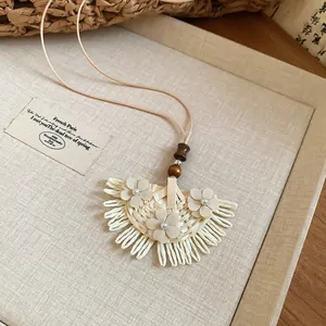Macro view of woven fan-shaped pendant with delicate flower accents