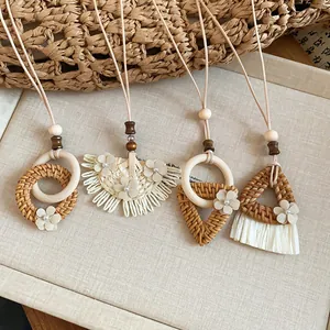 Detail view of handmade rattan woven pendant necklaces with floral and tassel accents