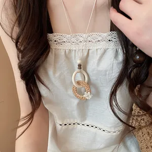 Detailed close-up of a new Chinese style rattan woven pendant necklace worn by a model