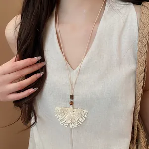 Handmade rattan woven skirt-shaped pendant necklace with delicate floral accents.