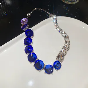 Elegant blue gradient crystal necklace shown in detail on a luxury white ceramic plate