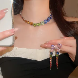 Detailed view of the rainbow gradient rhinestone necklace and matching fringe earrings set