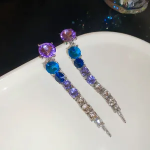 Macro view of elegant gradient round crystal tassel earrings with sparkling rhinestones