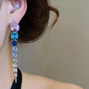 Close-up of elegant gradient rhinestone tassel earring with purple and blue crystals
