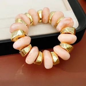 Gedetailleerd overzicht van elastische armband met perzik marmer acryl en goud