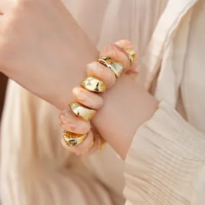 Detail van onregelmatige acryl marmeren kralen en goudkleurige kralen op armband