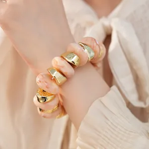 Gedetailleerd close-up van gouden geometrische en marmeren acryl kralen op een elastische armband