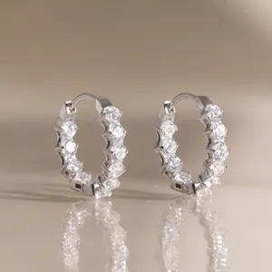Close-up of silver stainless steel hoop earrings with round clear cubic zirconia stones