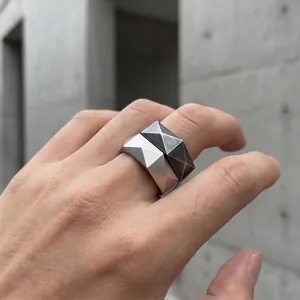 Nahaufnahme minimalistischer, geometrisch geschliffener Edelstahlringe mit Textur