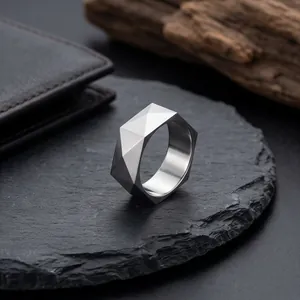 Detail eines minimalistischen facettierten Edelstahlrings mit geometrischem 3D-Schnitt.