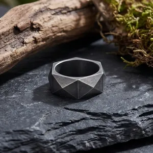 Makro-Detail eines minimalistischen geometrischen Edelstahlrings auf Stein-Hintergrund