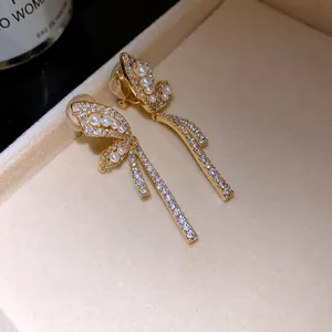 Vista dettagliata di orecchini a clip a farfalla in oro 18k con perle e zirconi brillanti