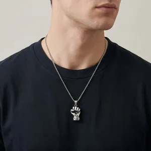 Primo piano della collana da uomo in acciaio inox con ciondolo a pugno punk.