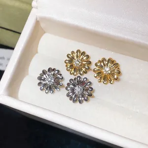 Pendientes de botón con forma de flor bañados en oro de 18k y circonitas brillantes.