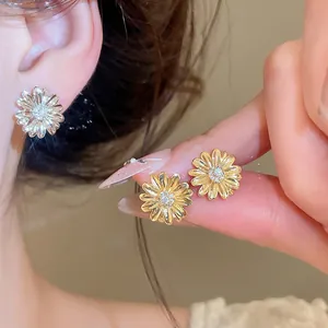 Primer plano de los pendientes de margaritas bañados en oro de 18 quilates con circonitas