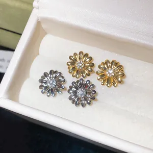 Detalle de pendientes de margaritas con circonitas bañados en oro de 18 quilates chic