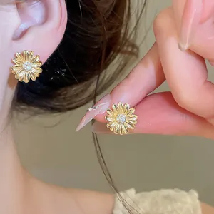 Elegantes pendientes de margarita en oro de 18k con detalle de circón