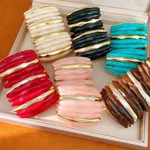 Detailed view of colorful acrylic marbled elastic bracelets with gold accents