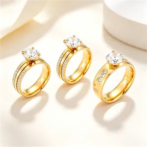 Détail de trois bagues en acier inoxydable doré serties de zircons de taille ronde.