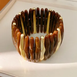 Close-up detail of a luxury acrylic marble and gold metal elastic cord bracelet