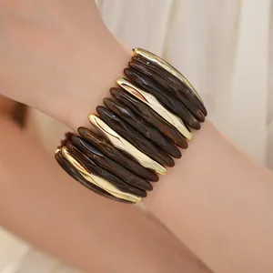 Close-up of marbled acrylic and gold elastic bracelet on wrist for a modern style.